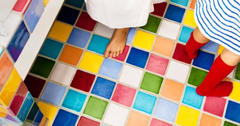 two people standing on multi-color square tiles
